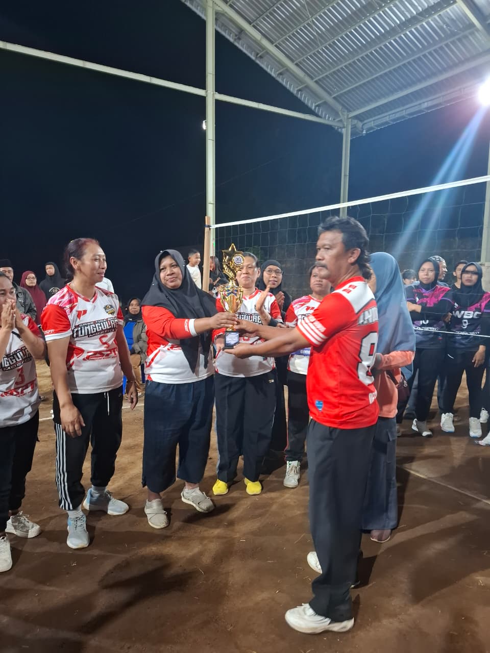 Penyerahan piala kepada juara lomba voli cawuk